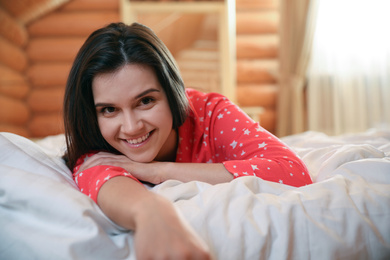 Photo of Young woman lying in bed at home. Lazy morning