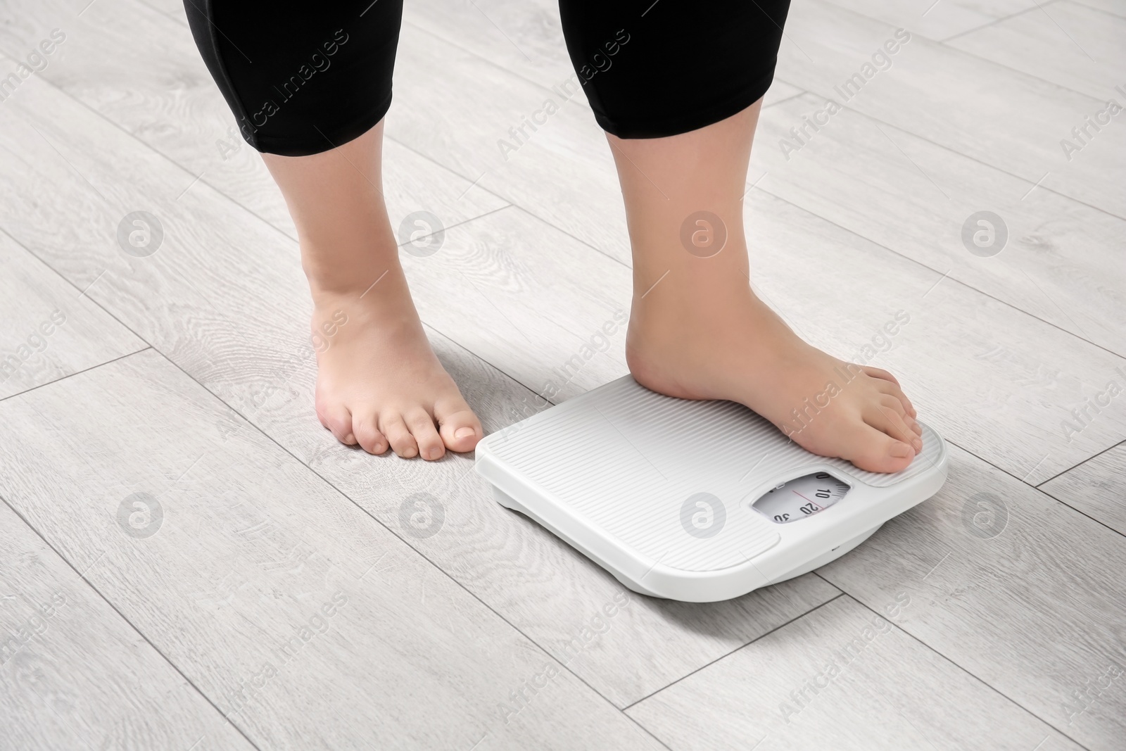 Photo of Overweight woman using scales indoors