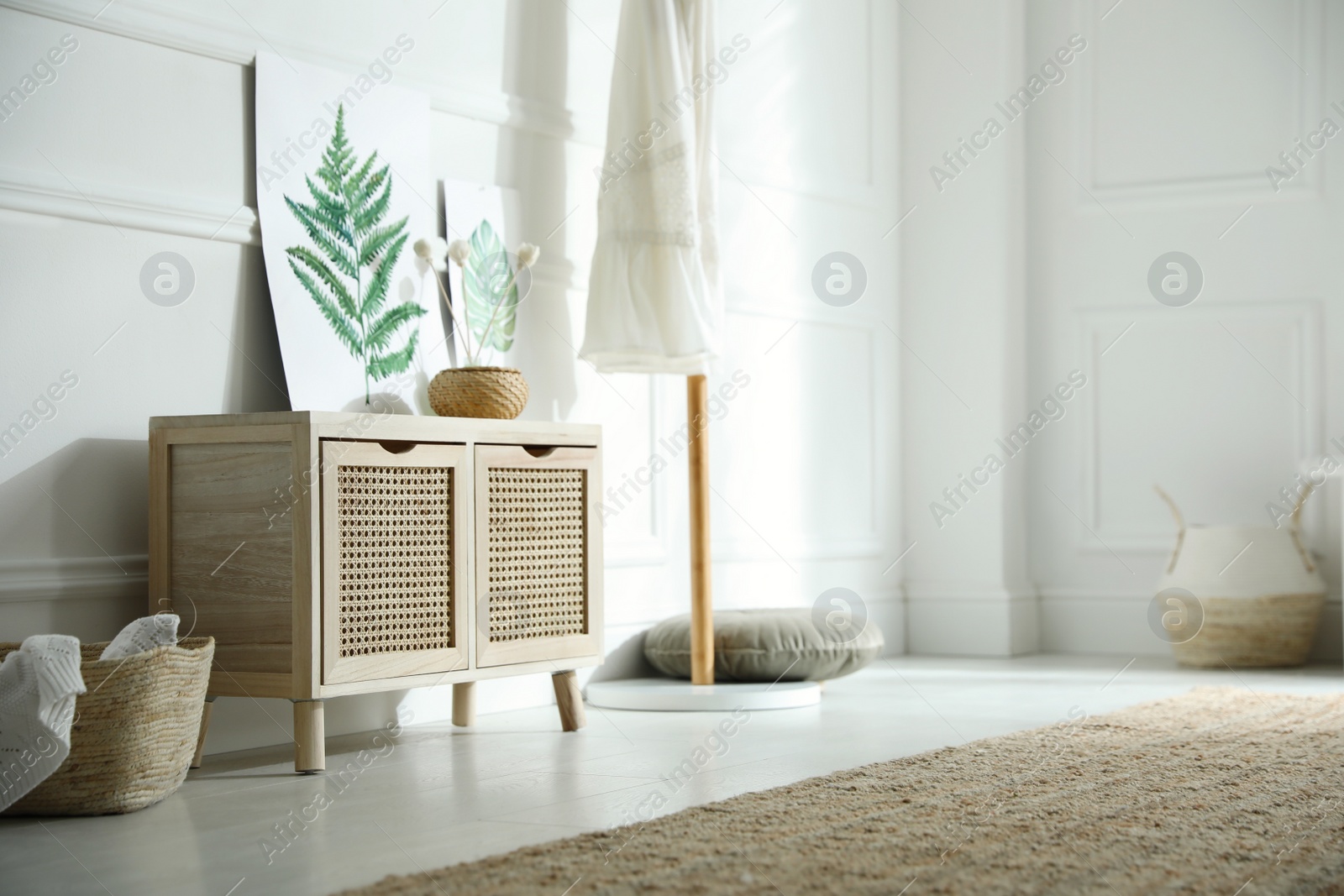 Photo of Wooden commode near white wall in room. Interior design