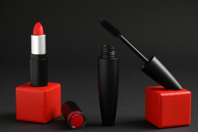 Photo of Beautiful lipstick and mascara on black background