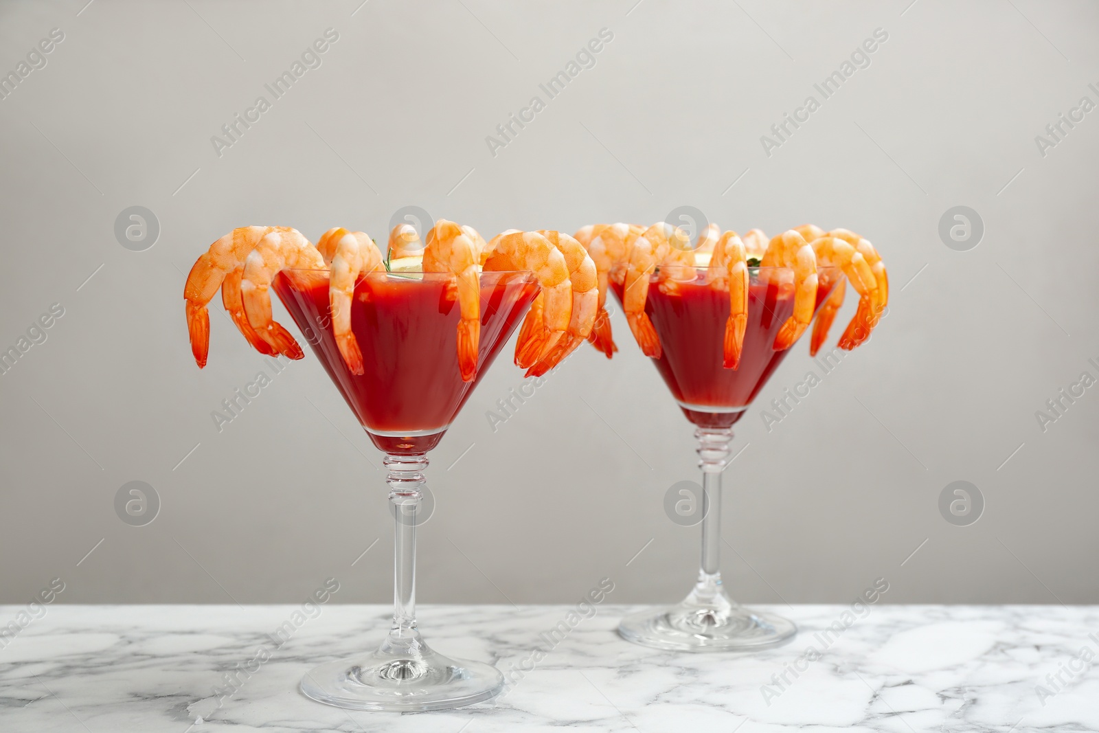 Photo of Shrimp cocktail with tomato sauce on marble table