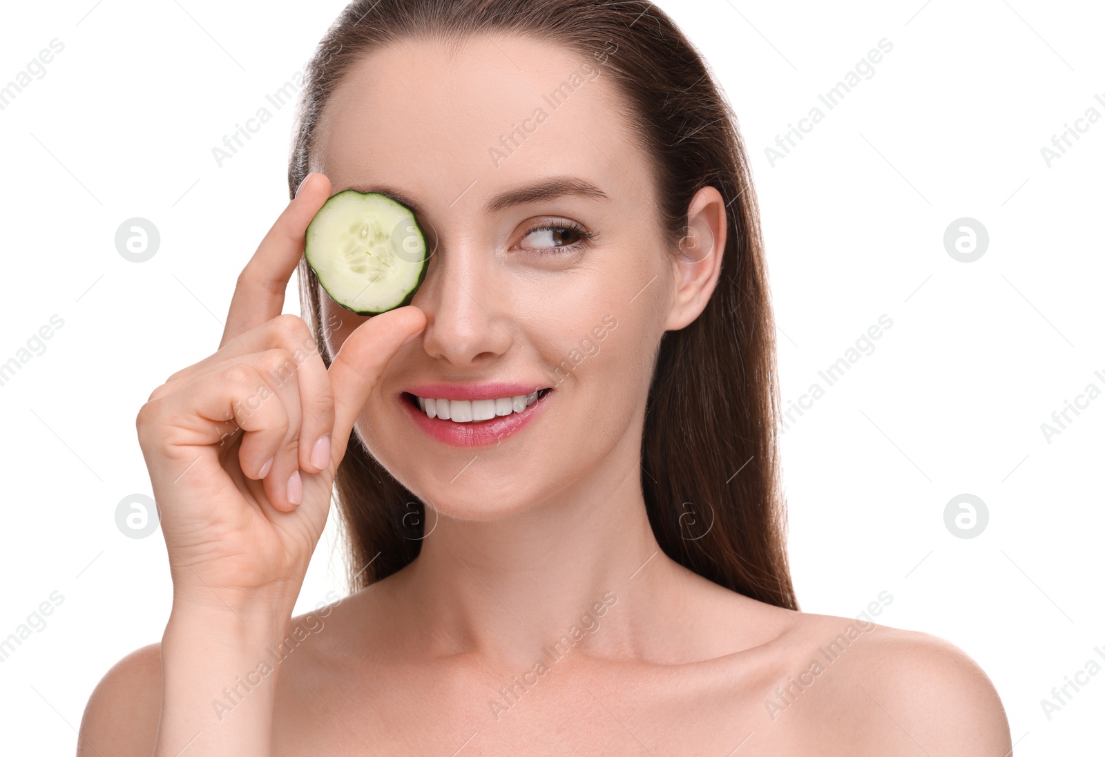 Photo of Beautiful woman covering eye with piece of cucumber on white background
