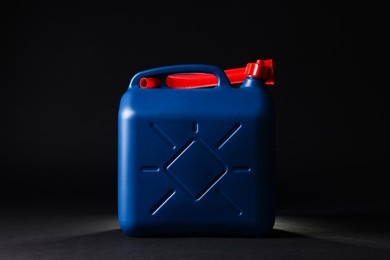 Photo of New blue plastic canister on black background