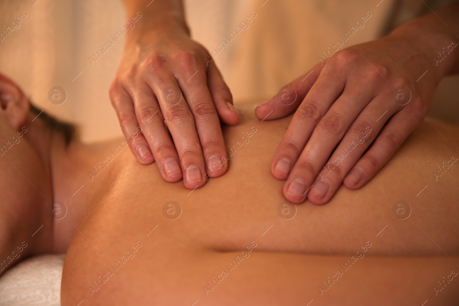 Photo of Young woman receiving back massage in spa salon, closeup