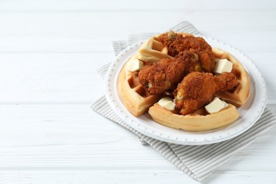 Photo of Delicious Belgium waffles served with fried chicken and butter on white table, space for text