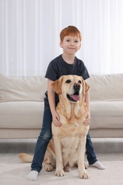 Cute child with his Labrador Retriever at home. Adorable pet