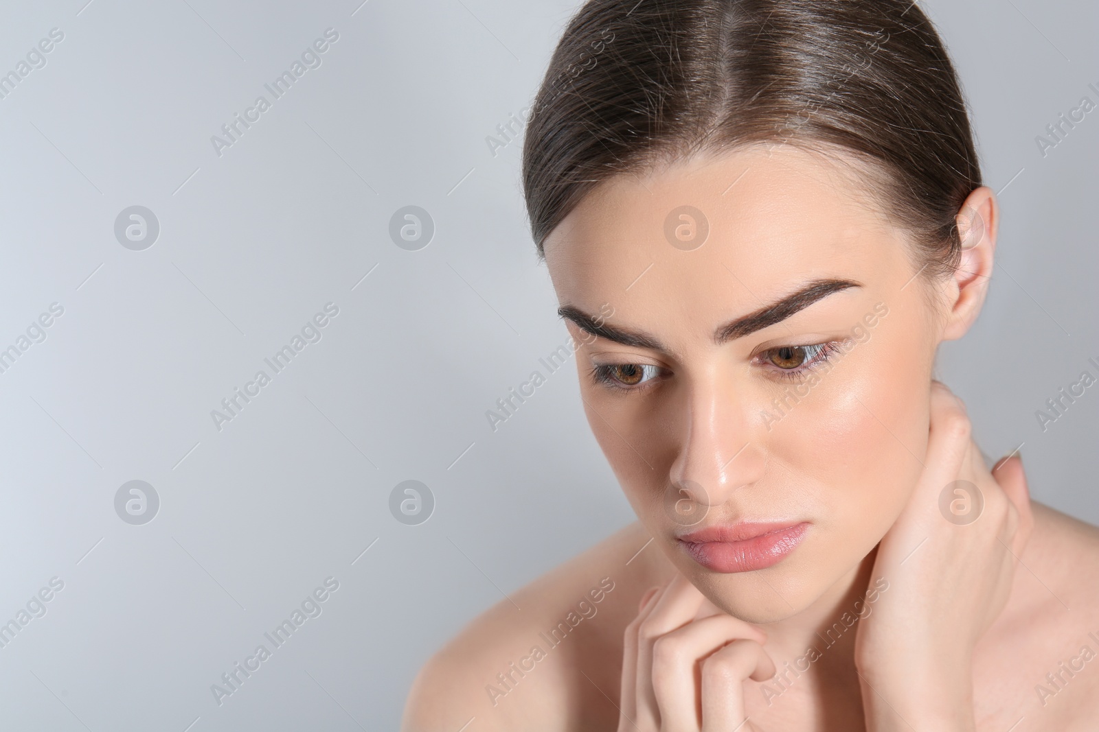 Photo of Beautiful woman with perfect eyebrows on light background