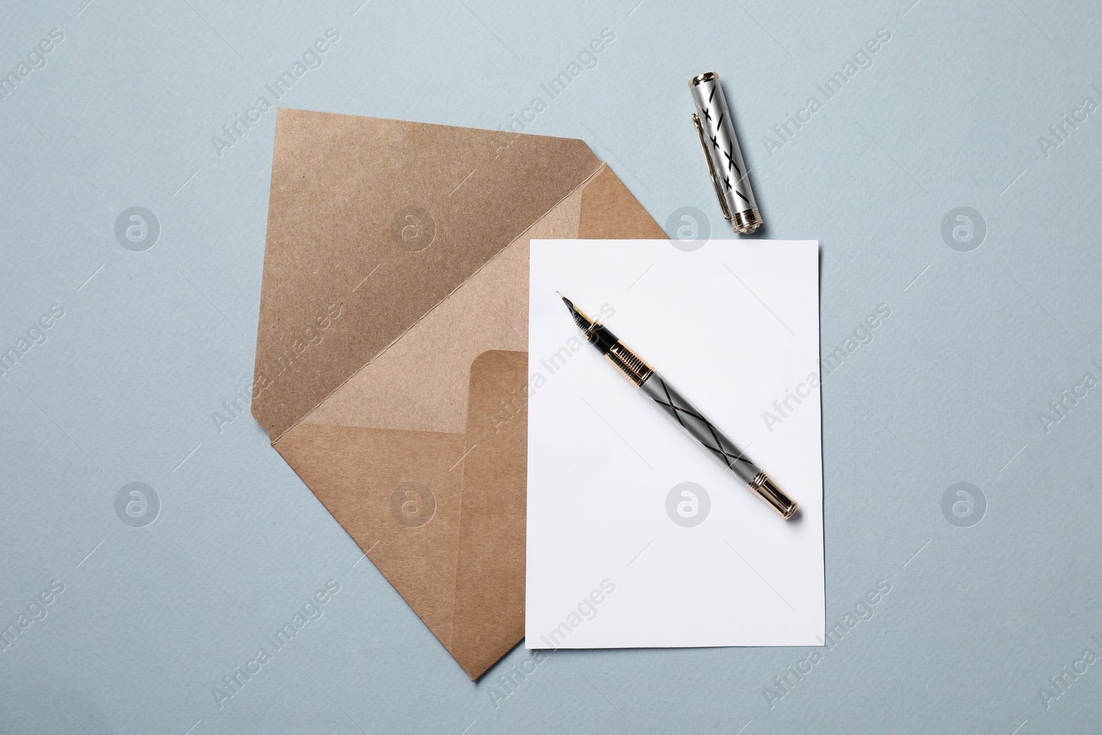 Photo of Blank sheet of paper, letter envelope and pen on grey background, top view