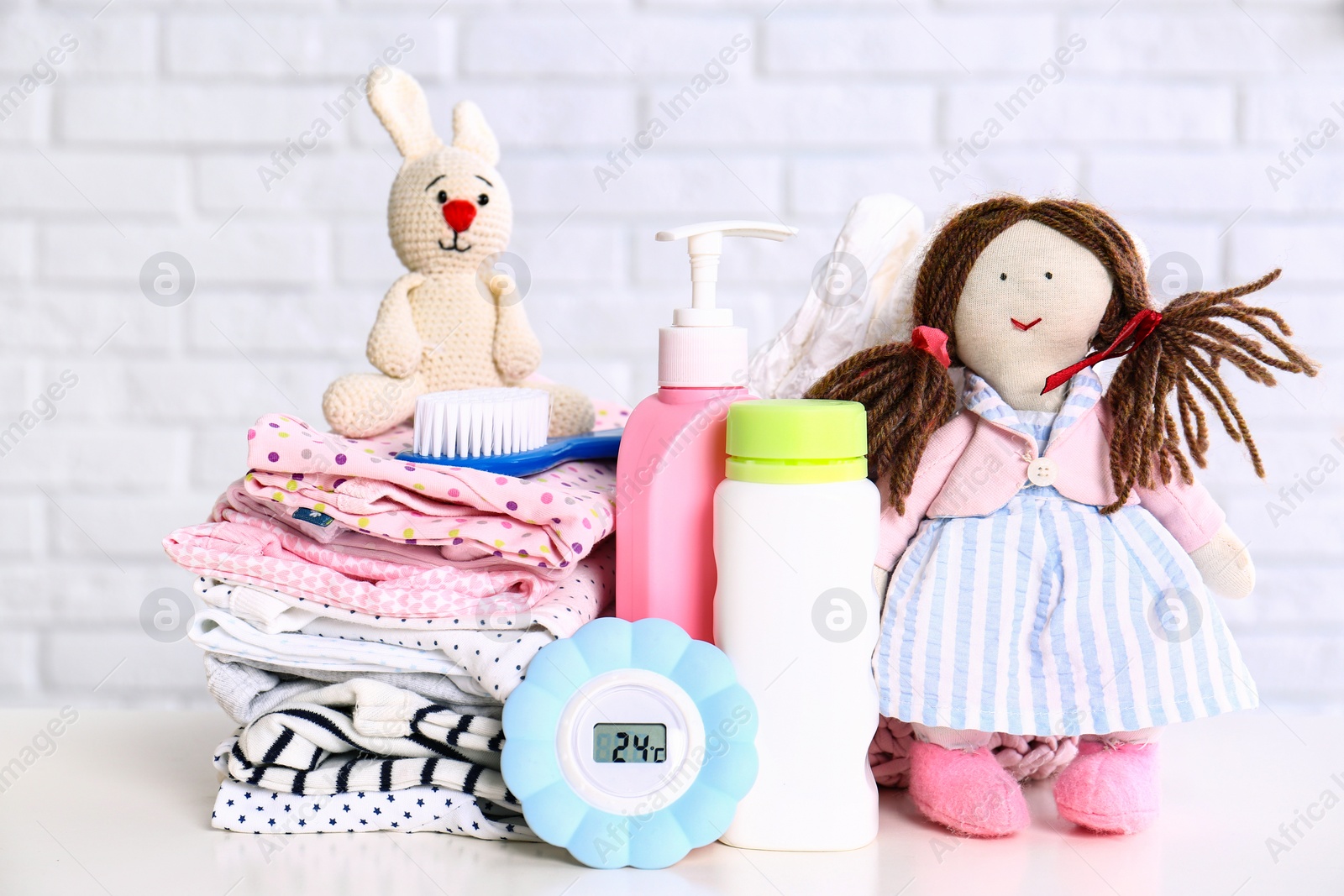 Photo of Baby accessories on table near white brick wall