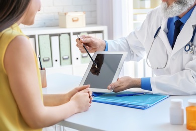 Photo of Mature doctor consulting patient in clinic