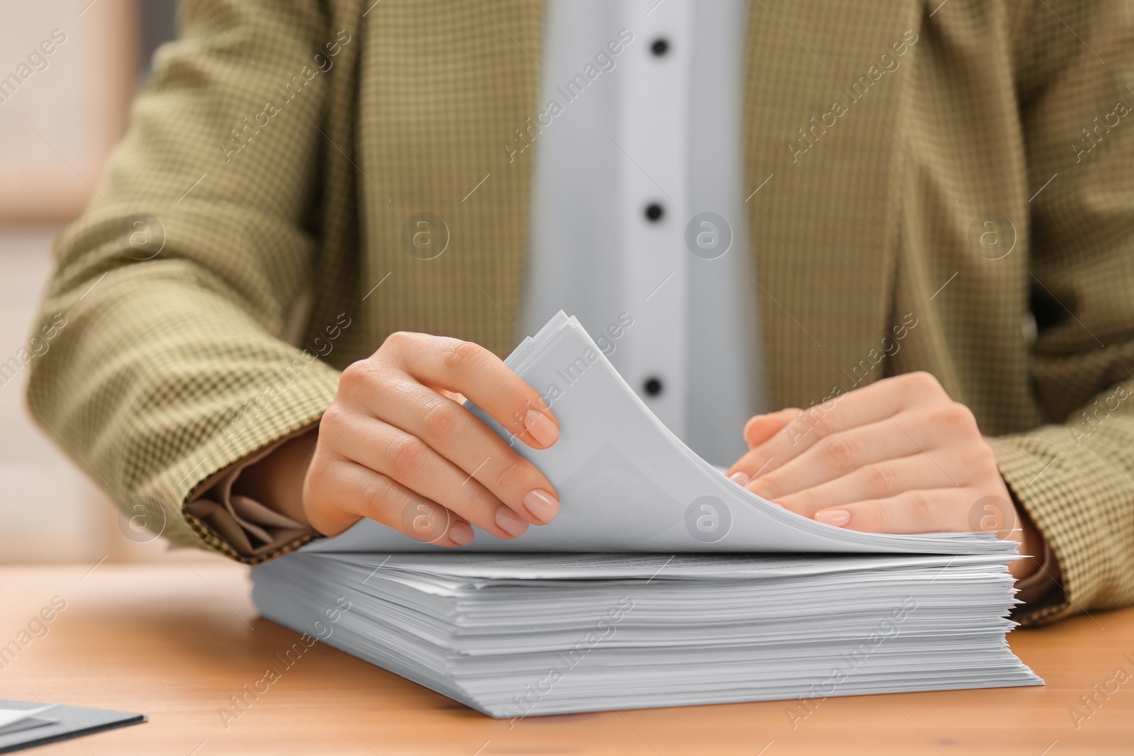 Photo of Woman working with documents at table in office, closeup