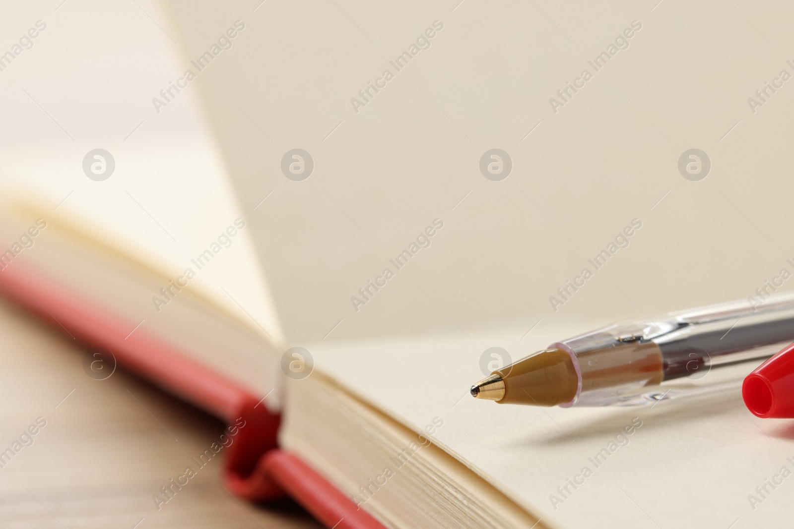 Photo of Ballpoint pen and notebook on table, closeup. Space for text