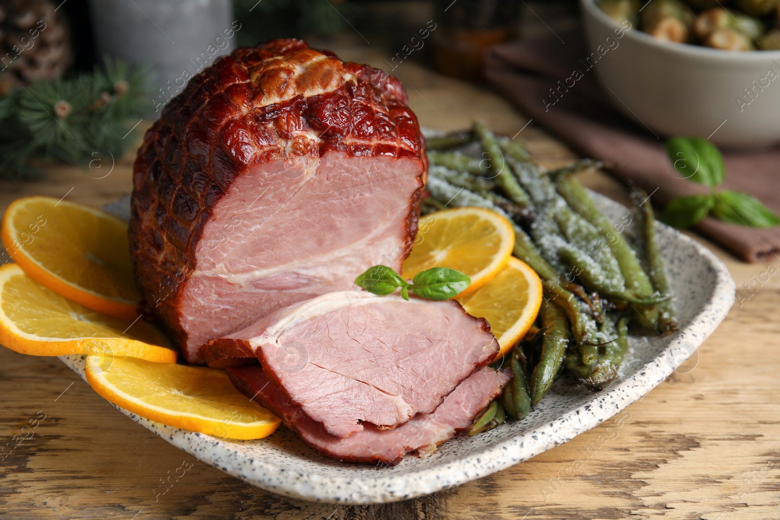 Photo of Delicious ham served with green beans and orange on wooden table, closeup. Christmas dinner