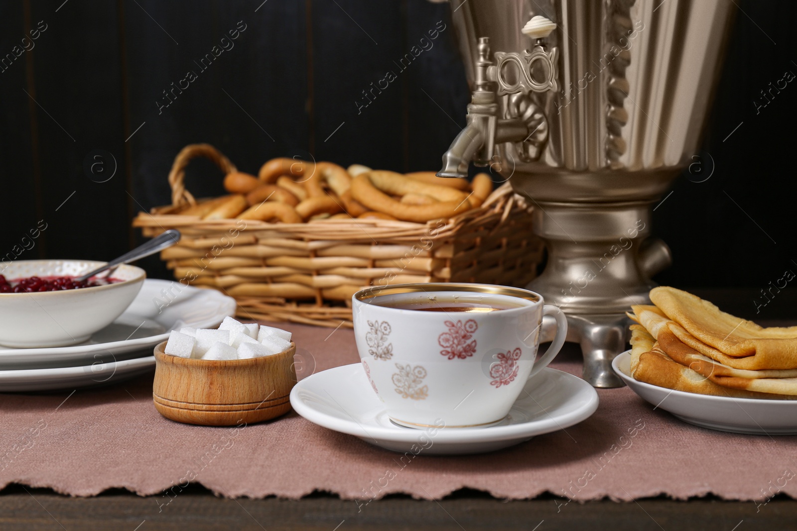 Photo of Aromatic tea, traditional Russian samovar and treats on table