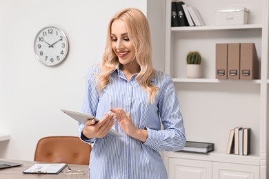 Portrait of happy secretary with tablet in office