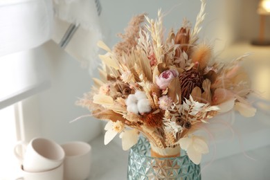 Bouquet of dry flowers and leaves on countertop in kitchen