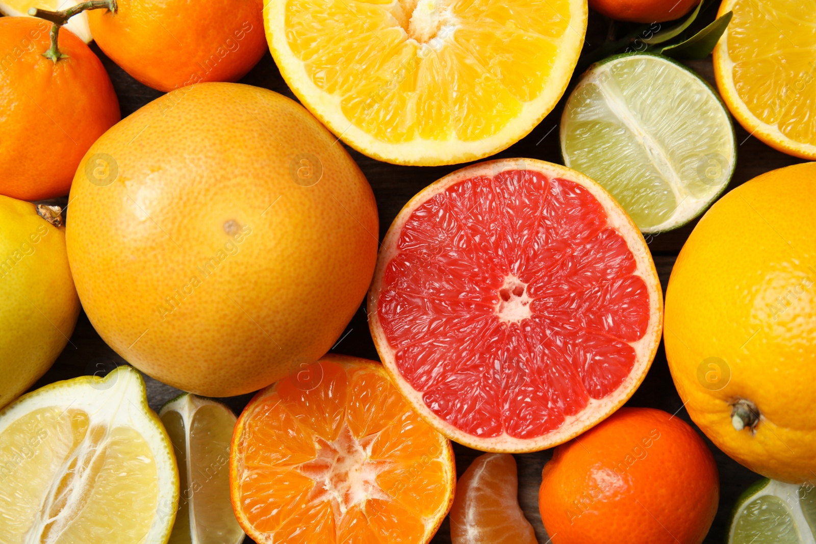 Photo of Different citrus fruits as background, top view