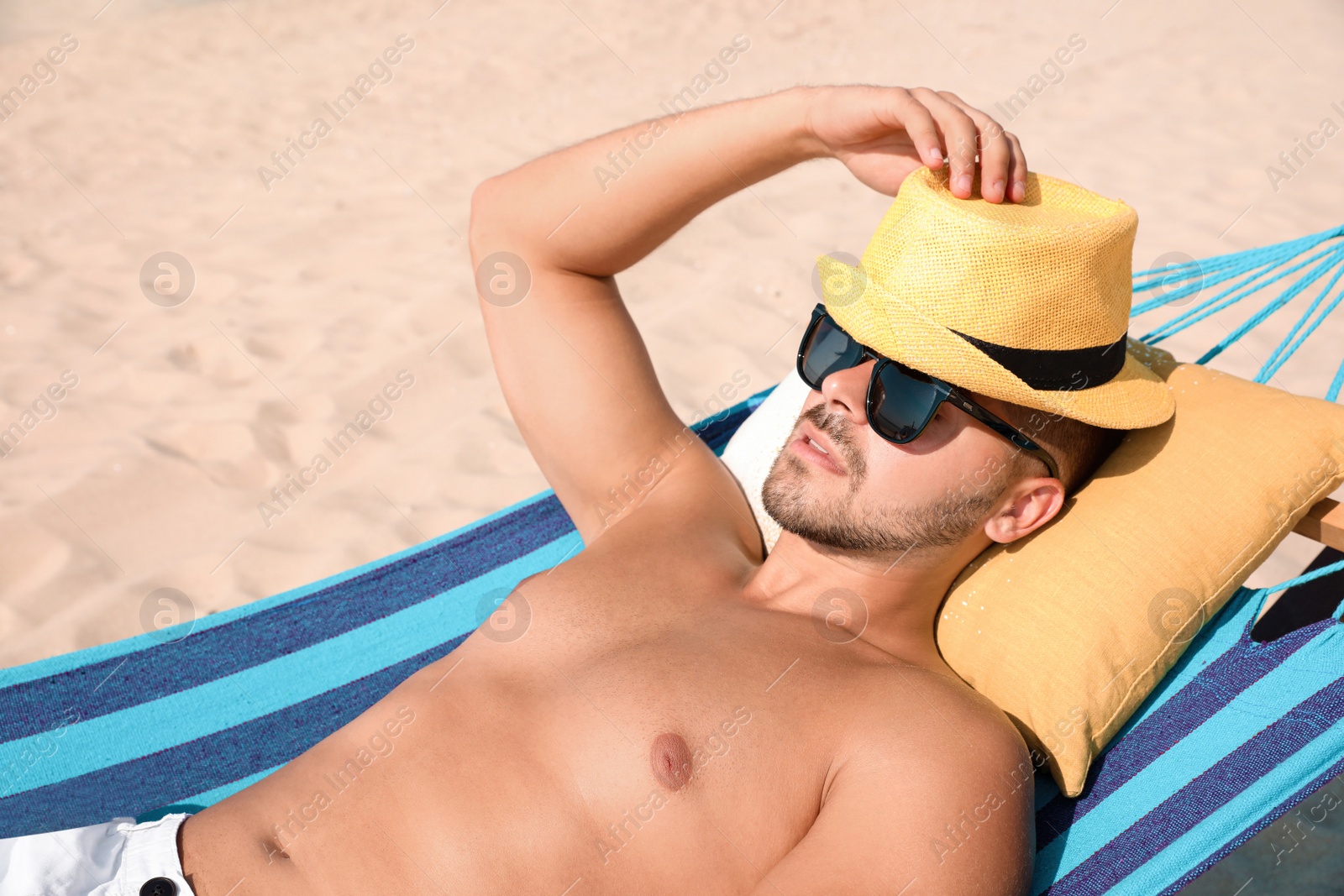 Photo of Young man relaxing in hammock on beach