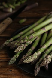 Photo of Fresh raw asparagus on wooden table, closeup