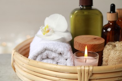 Photo of Beautiful composition with different spa products and burning candle on light table, closeup