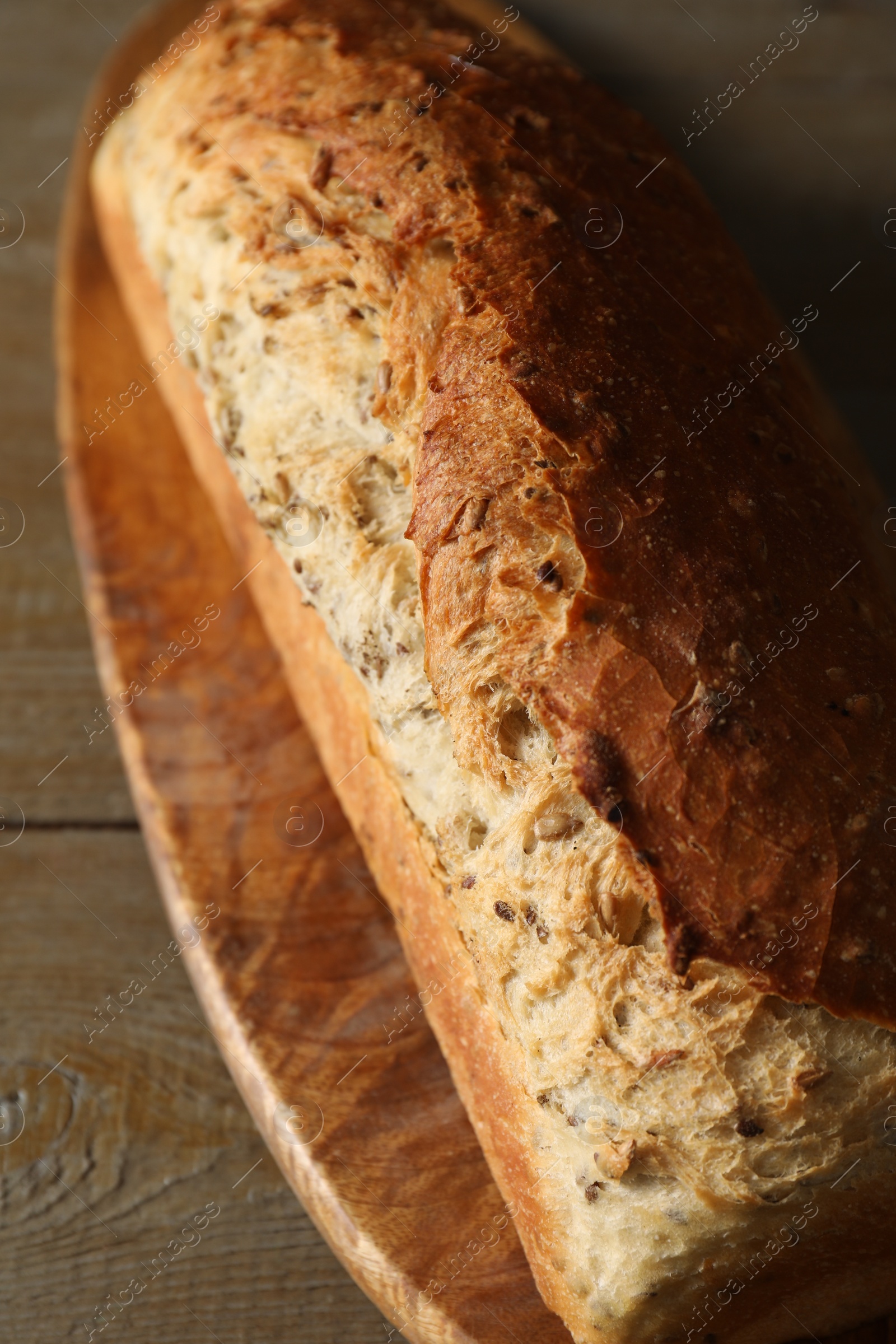 Photo of Freshly baked sourdough bread on wooden table, closeup