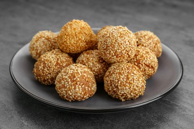 Photo of Many delicious sesame balls on grey table, closeup