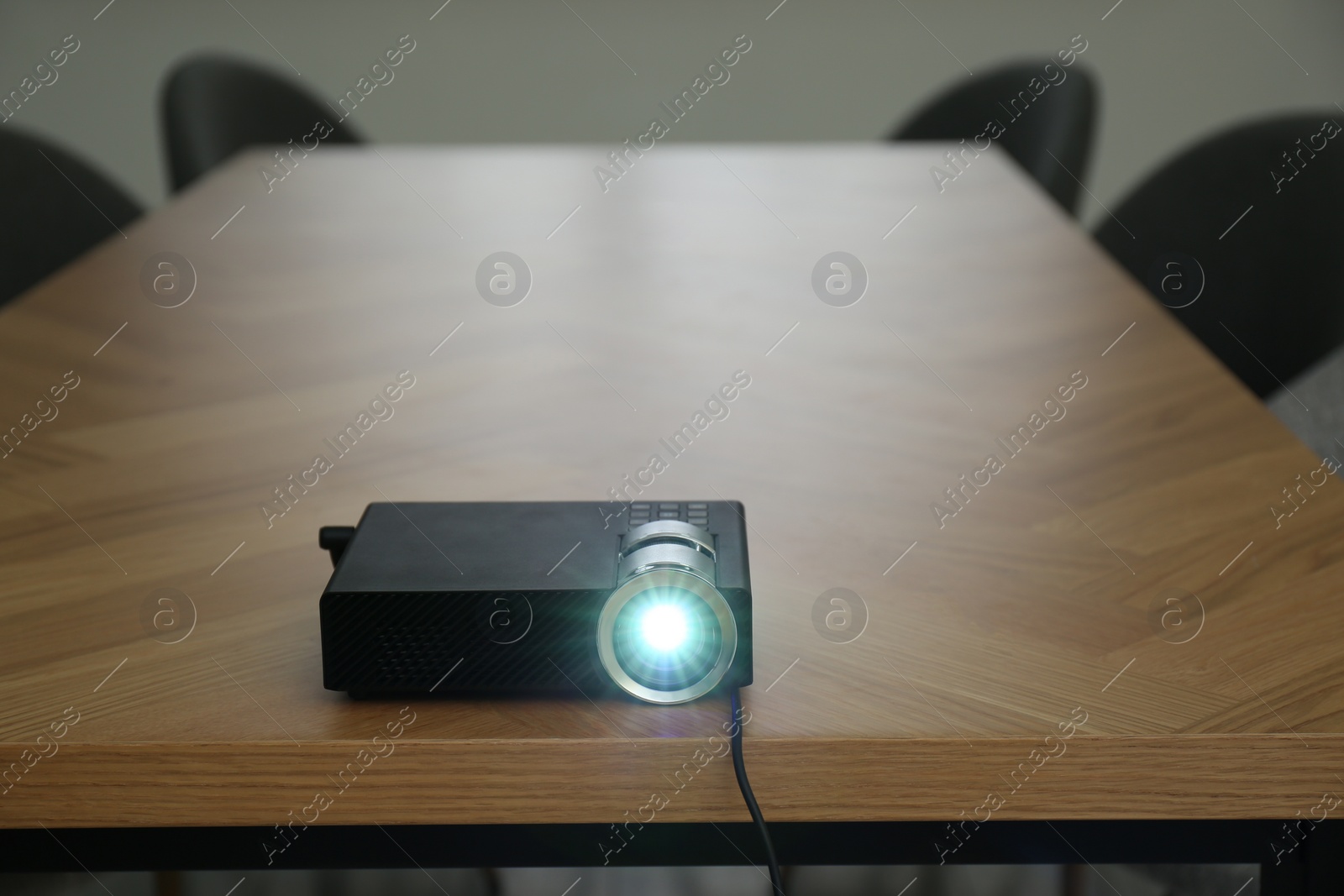 Photo of Modern video projector on wooden table in conference room