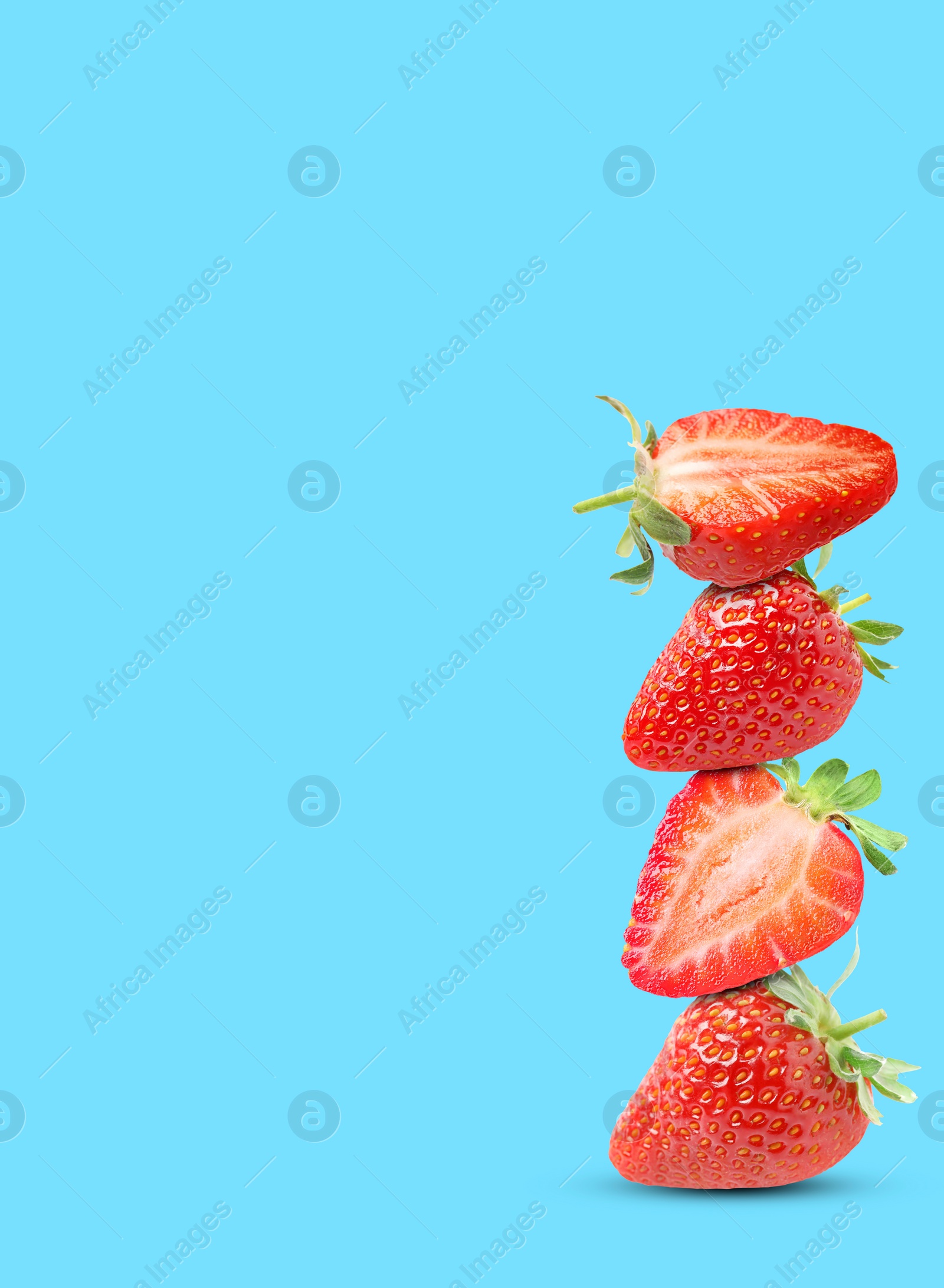 Image of Stack of fresh strawberries on light blue background, space for text