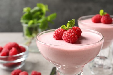 Photo of Glass of delicious raspberry mousse with mint, closeup