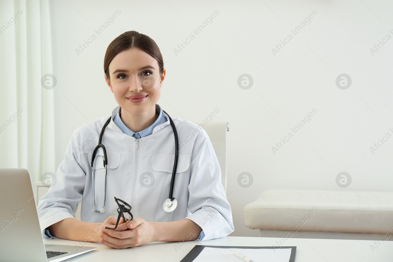 Photo of Portrait of young female doctor in white coat at workplace