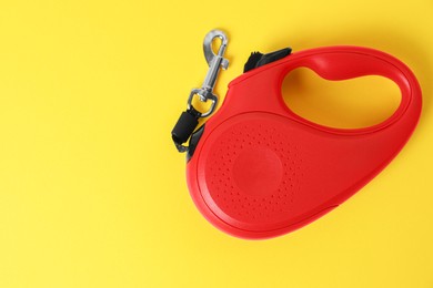 Photo of Red dog retractable leash on yellow background, top view. Space for text