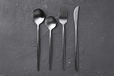 Photo of Beautiful cutlery set on black table, flat lay