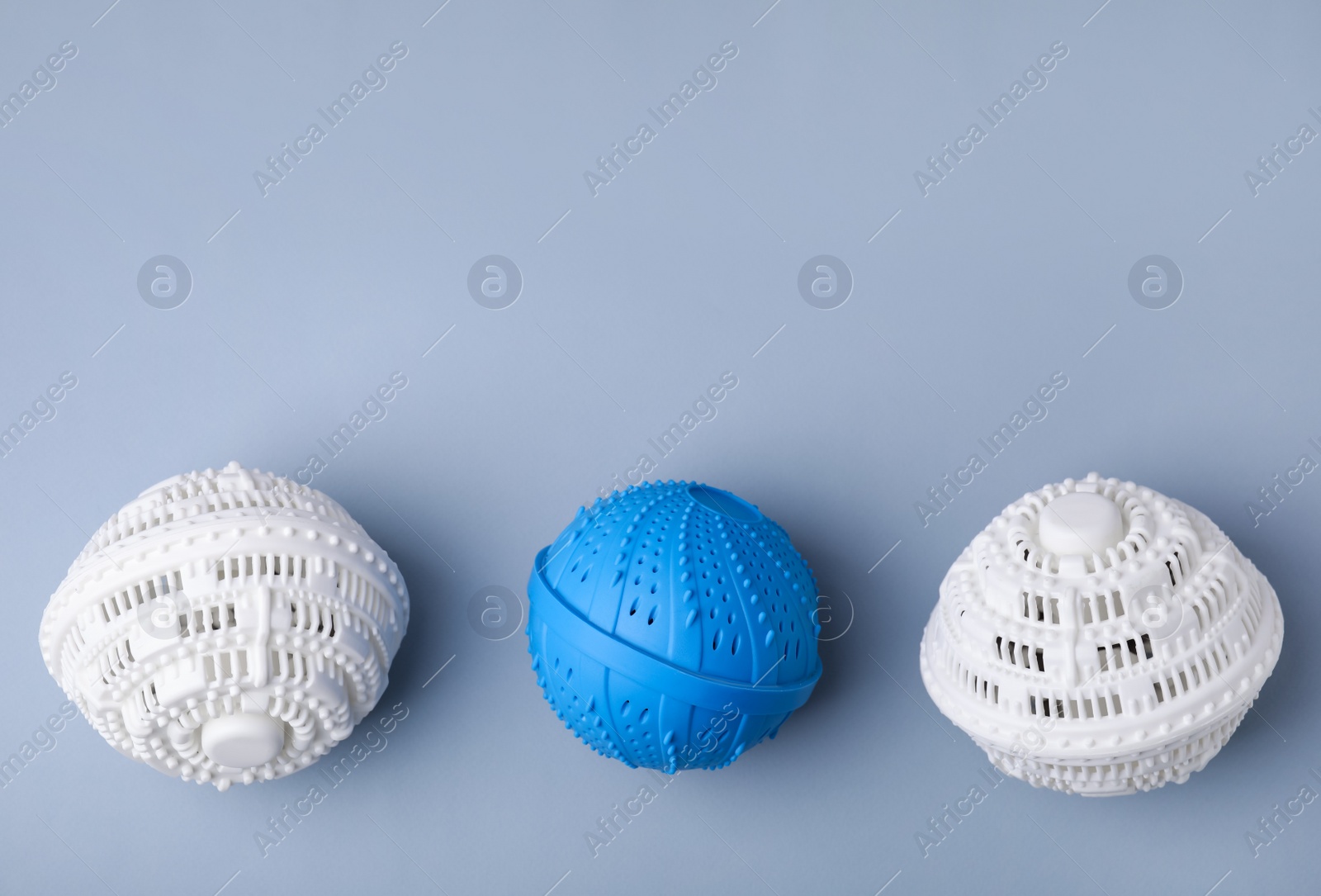 Photo of Laundry dryer balls on light grey background, flat lay. Space for text