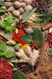 Different fresh herbs with aromatic spices as background, top view