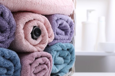 Camera hidden between towels in bathroom. Space for text