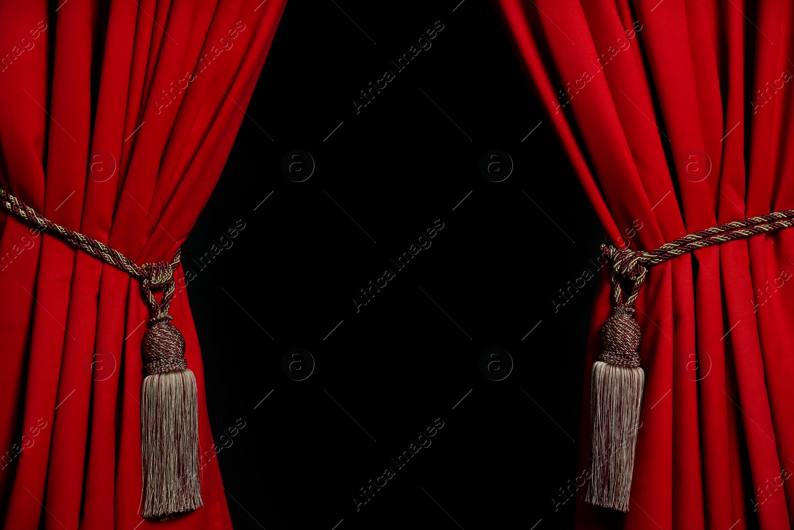 Photo of Open elegant red front curtains on black background. Space for text