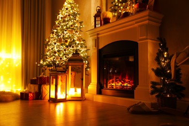 Beautiful fireplace, Christmas tree and other decorations in living room at night. Interior design