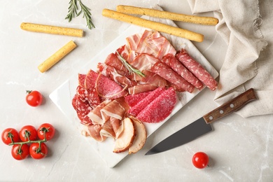 Flat lay composition with different meat delicacies on gray background