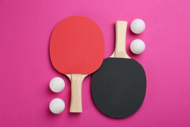 Ping pong rackets and balls on pink background, flat lay