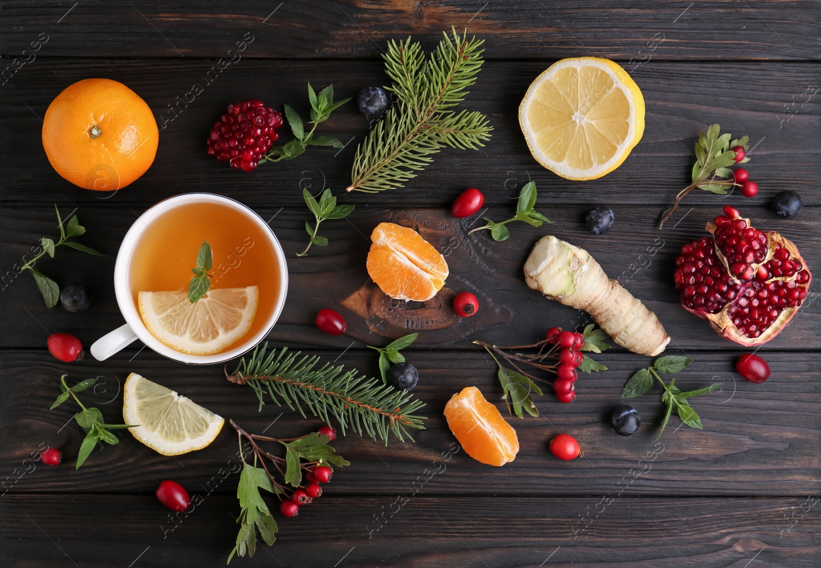 Photo of Flat lay composition with cup of delicious immunity boosting tea and ingredients on wooden table