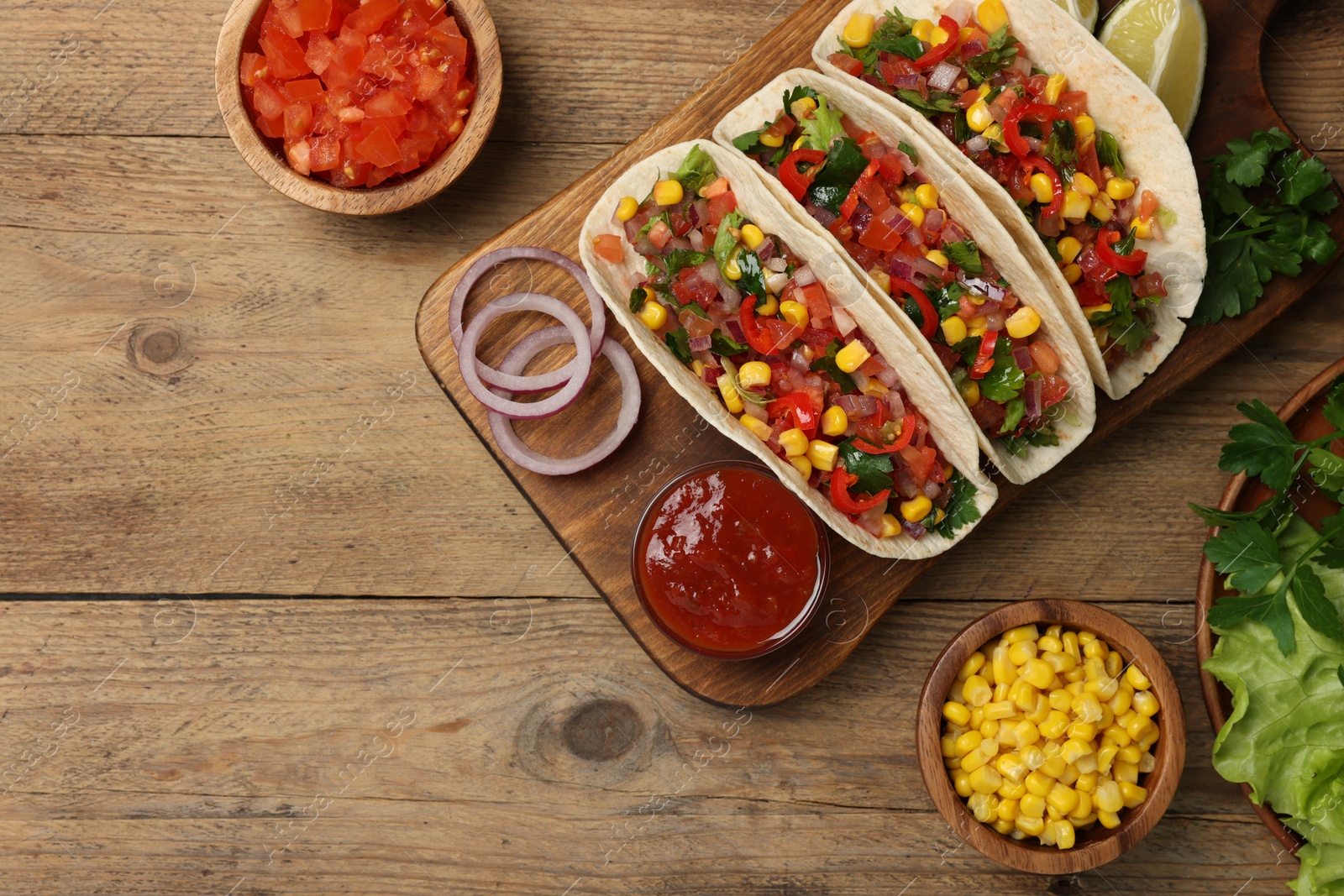 Photo of Tasty tacos with vegetables on wooden table, flat lay. Space for text