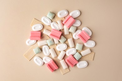 Photo of Many different chewing gums on beige background, flat lay
