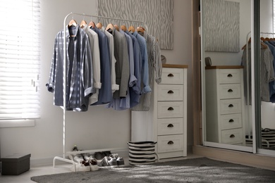 Photo of Dressing room interior with clothing rack and chest of drawers