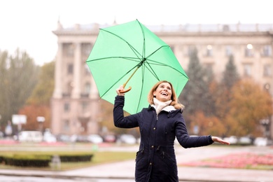 Photo of Woman with umbrella in city on autumn rainy day