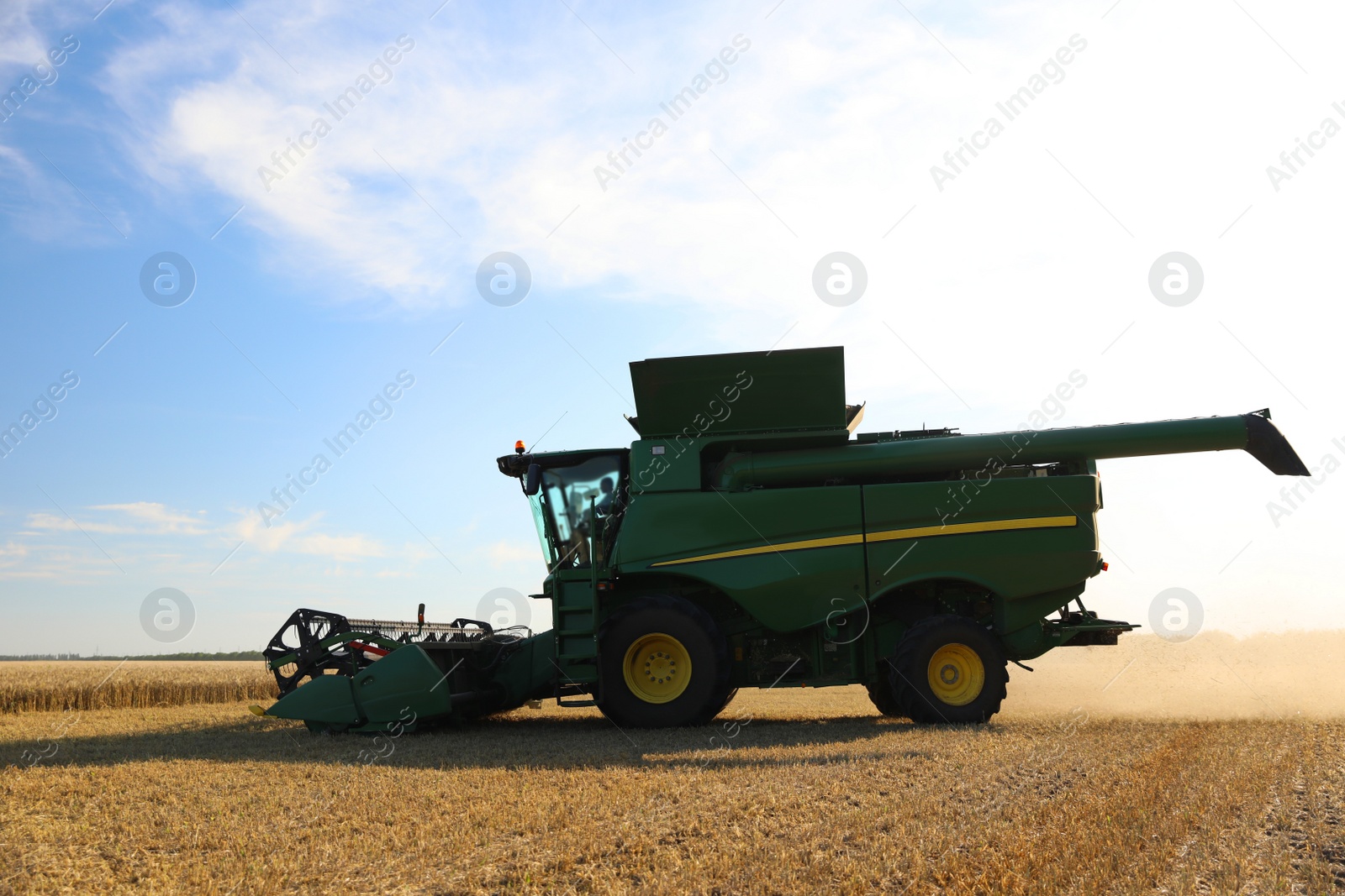 Photo of Modern combine harvester working in agricultural field