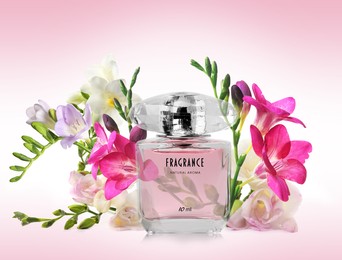 Bottle of luxury perfume and beautiful flowers on color background