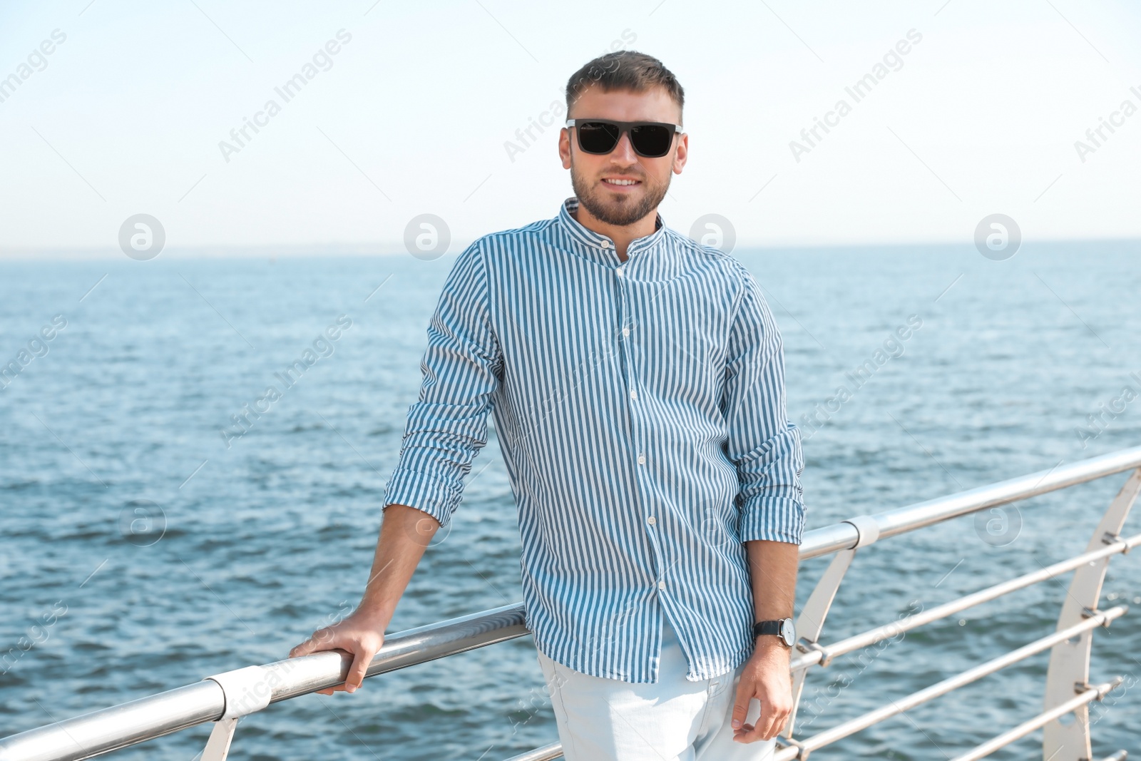 Photo of Portrait of handsome young man on sea pier