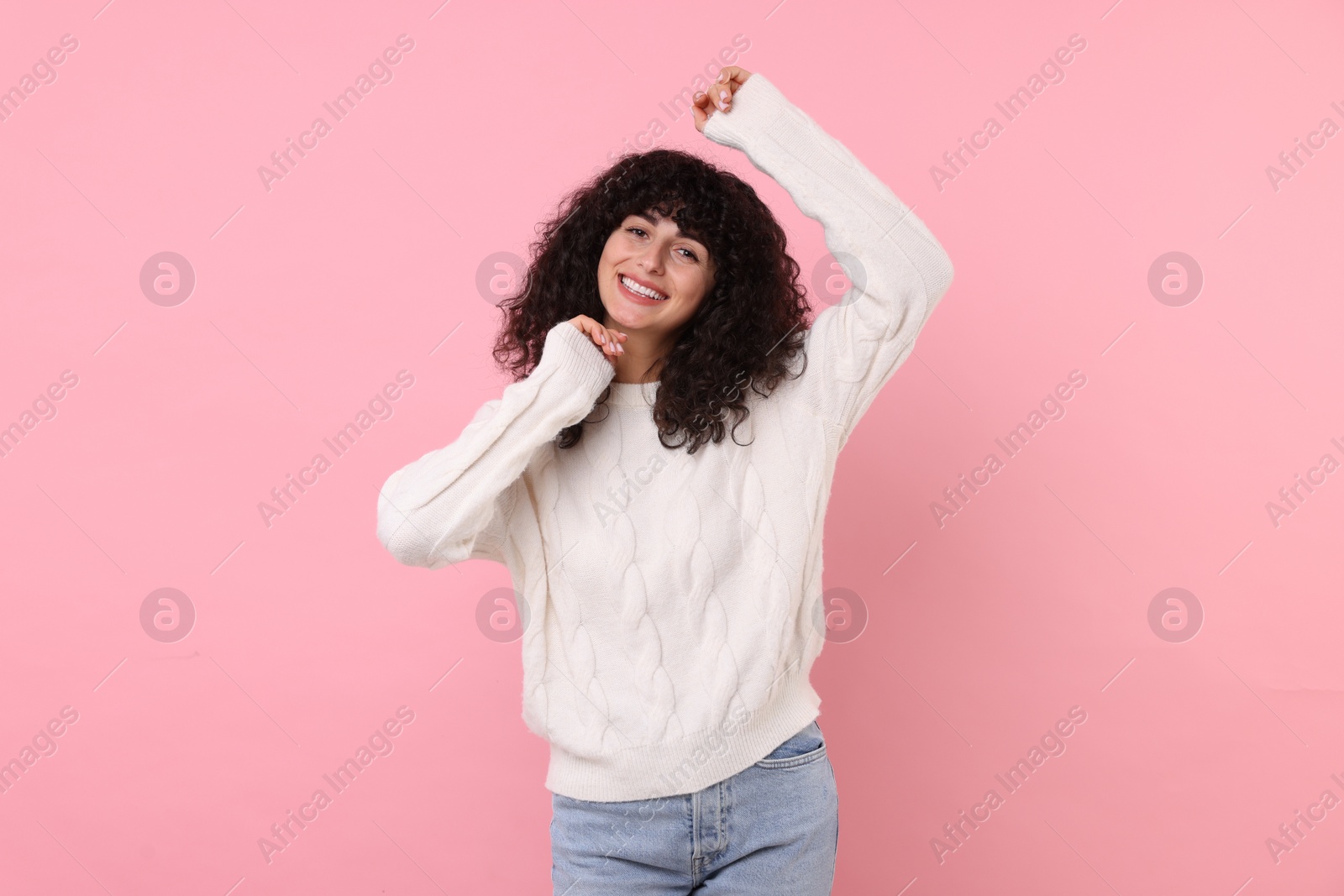 Photo of Happy young woman in stylish white sweater on pink background