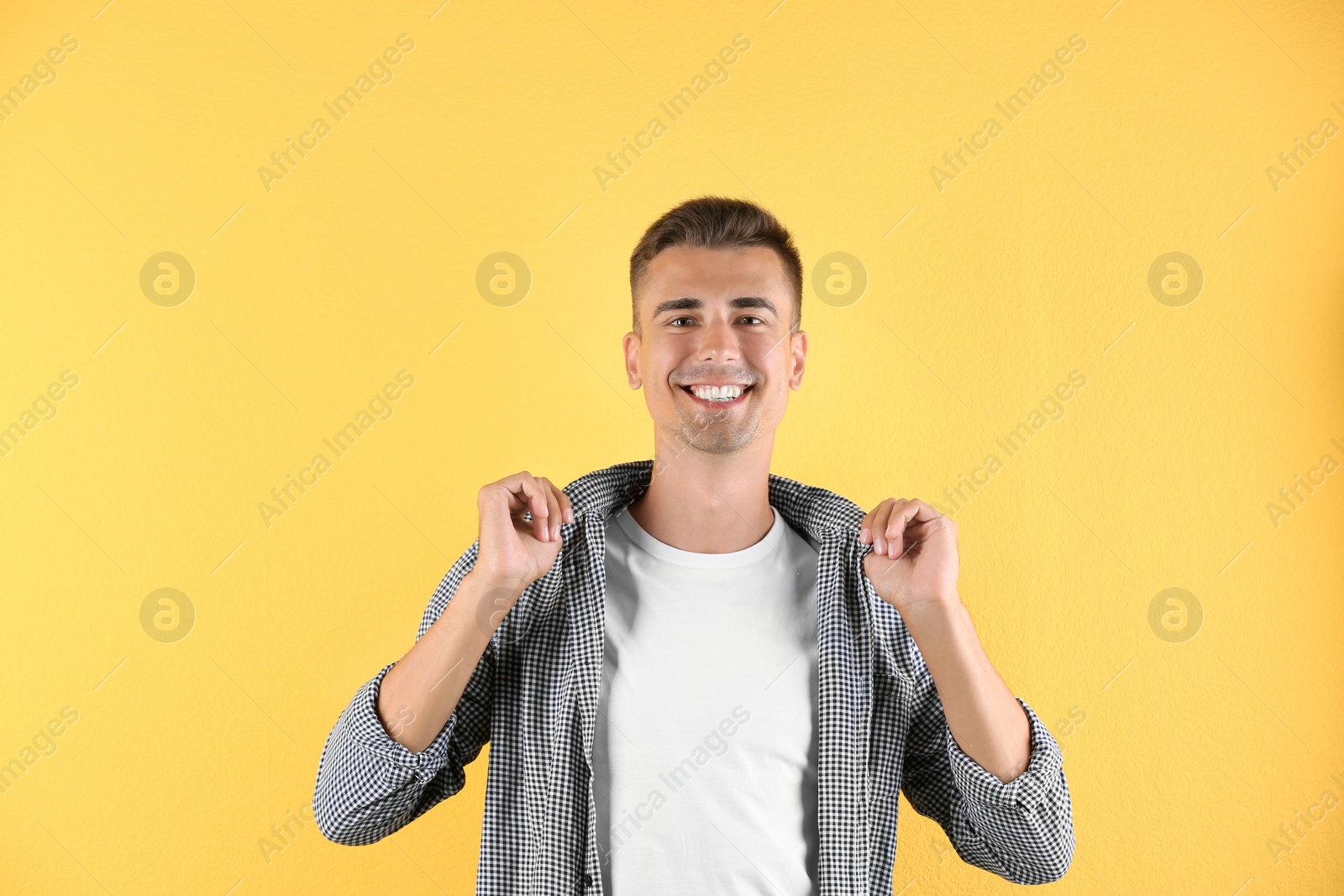 Photo of Handsome young man smiling on color background