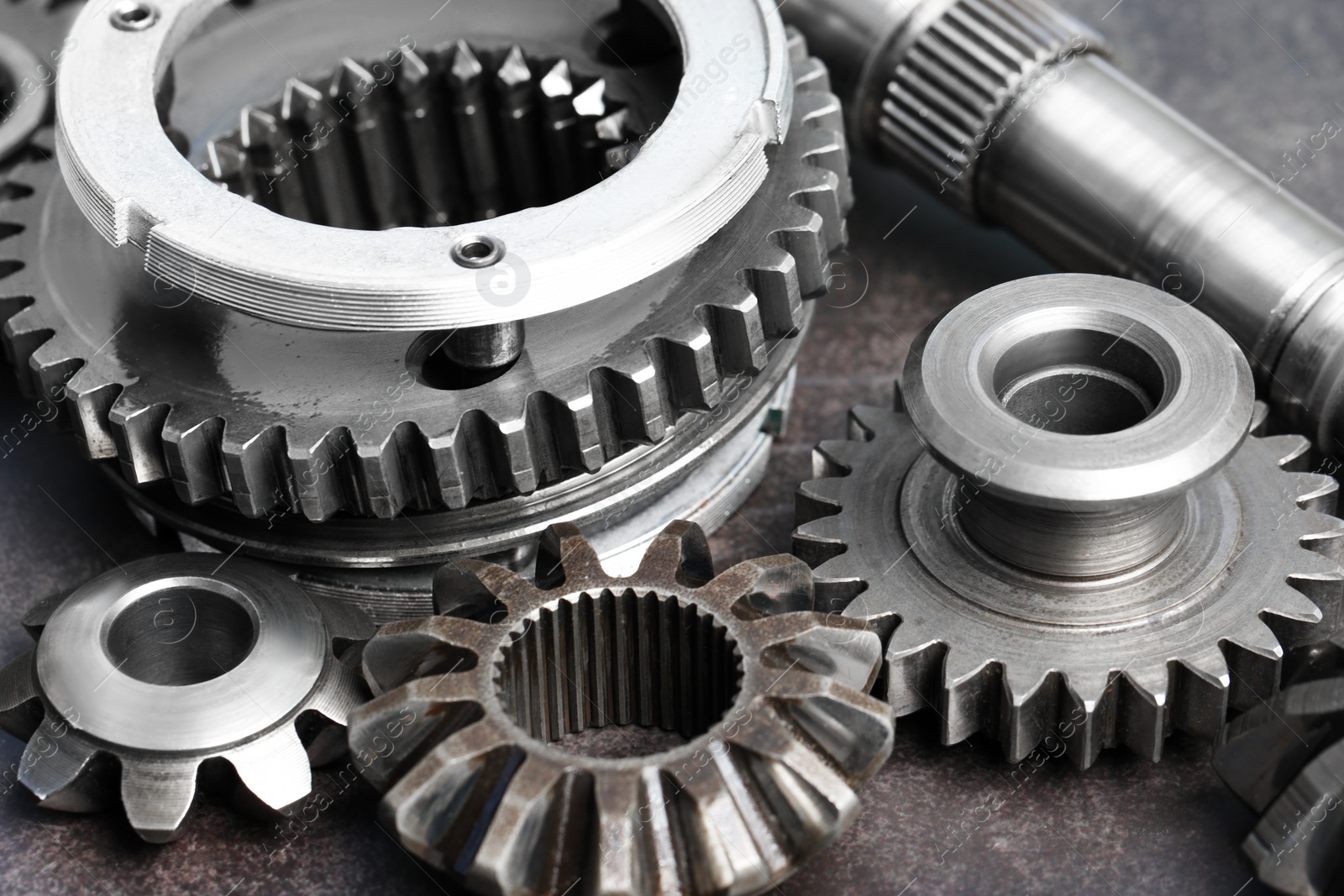 Photo of Different stainless steel gears on grey background, closeup
